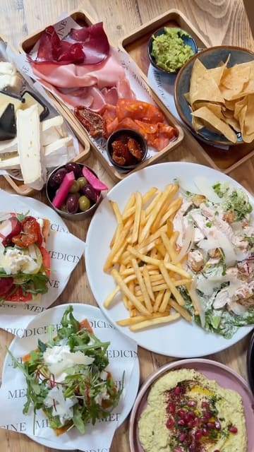 A creator visits Medicine Bakery at the Ikon Gallery to review their new weekend dining menu, showcasing a variety of food and drink options including espresso martinis, focaccia, and charcuterie boards, while highlighting the venue's outdoor seating and atmosphere.