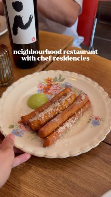 A concise and visually appealing review of Naughty Piglets in Brixton, highlighting the unique guest chef residency program, the sharing plates, and the wine-focused atmosphere.