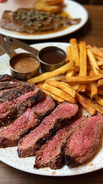 A video review of Bordelaise in Tooting Market, featuring a variety of French bistro dishes including steak, plaice meunière, scallops, and tarte tatin, alongside shots of the cozy, mural-decorated interior.