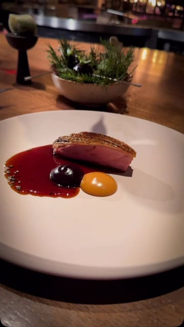 A series of cinematic, slow-motion shots showcasing an eight-course tasting menu at IGNI in Mayfair. The video highlights the intricate plating and the open-flame cooking technique used in the kitchen, set to music without any voiceover or text overlays.