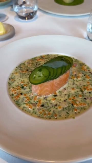 A montage of high-end dishes and wine service at a restaurant, featuring close-up shots of plated food and table service.