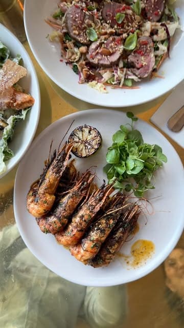 A group of friends visits The Lighterman in King's Cross, showcasing the waterfront location, cocktails, and a variety of dishes including pizza, salad, prawns, and dessert.