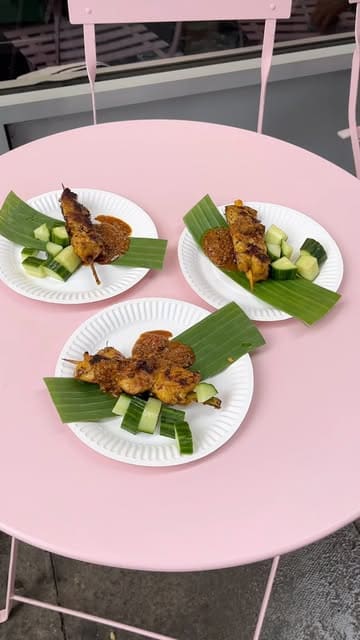 A short, energetic video documenting a satay pop-up event hosted at a local butcher shop. The video features the cooking process, the setup, and customers enjoying the food despite the rainy weather.