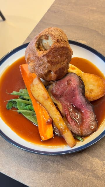 A short, engaging video review of a Sunday roast at Hemisphere restaurant in Nottingham. The video features close-up shots of the roast beef, Yorkshire pudding, roast potatoes, honey glazed parsnips, and cauliflower cheese, accompanied by a voiceover describing the quality and taste of the food. The video also includes brief shots of the restaurant interior.
