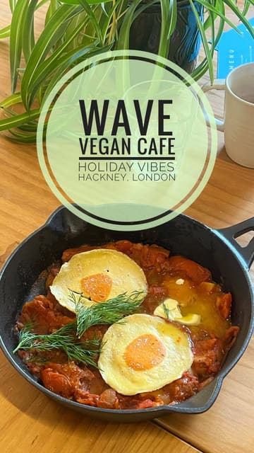 A vlog-style review of a vegan cafe in Hackney, featuring a tour of the interior, outdoor seating, and a taste test of various menu items including coffee, a Mediterranean schiacciata, vegan shakshuka, pastries, and a miso cookie.