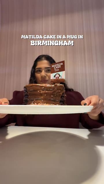 A short, energetic video featuring a creator reviewing the 'Matilda Cake in a Mug' at Haute Dolci in Birmingham. The video uses quick cuts, voiceover, and close-up shots of the dessert being prepared and eaten to highlight the product for World Chocolate Day.