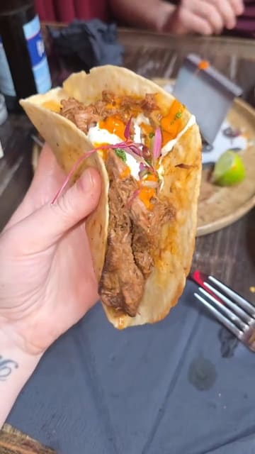 A short, energetic vlog-style video featuring a visit to Bizarron, a Latin American restaurant. The creator provides a tour of the interior, showcases a variety of small plates including Padron peppers, chicken mole croquettes, and beef birria tacos, and shares her positive experience.