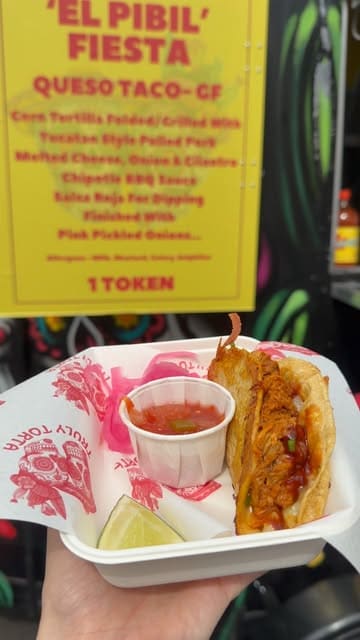 A vlog-style reel showcasing a food tour at a bank holiday event, featuring various street food vendors including a Brazilian chicken bowl, a pulled pork taco, and a donut.