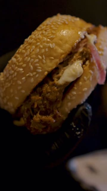 A food review video where the creator visits Black Bear Burger in Westfield Shepherd's Bush, showcasing various starters and a brisket burger, providing an honest critique of the food quality.