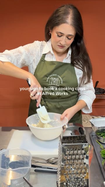 A montage video showcasing a cooking class experience at Alfred Works, featuring participants preparing meze dishes and cocktails in a collaborative kitchen setting.