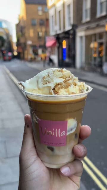 The creator visits 'Unilla' in London to try their banana pudding, specifically testing a 'latte banana pudding' combination. The video features the shop's exterior, the preparation of the dessert, and the creator's honest review of the taste.