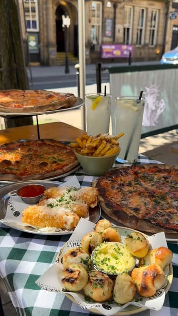 A short, punchy montage focusing on the food offerings at Fratelli Della, featuring close-ups of pizza, mozzarella sticks, dough balls, and fries. The video highlights the textures and cheese pulls, effectively creating a strong appetite appeal.