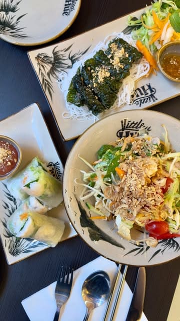 A short-form video review of Little Hue in Edinburgh, showcasing a variety of Vietnamese dishes including summer rolls, papaya salad, Bun Bo Hue, and a hot stone Pho, alongside their signature salt coffee.