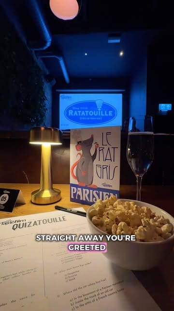 A review of a 'Taste Film' cinema dining experience at The Button Factory in Birmingham. The creator explains the concept of eating themed dishes while watching a movie, showcasing the venue, the themed popcorn, drinks, and food courses.