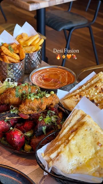 A promotional video for Desi Fusion in Aldridge, featuring a variety of Indian street food dishes, including a mixed grill platter, curries, and naan, alongside shots of the restaurant's interior and exterior.