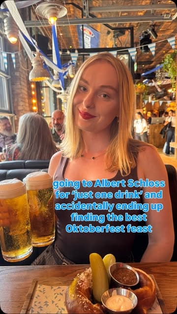 A promotional reel for Albert's Schloss featuring their Oktoberfest menu, including large steins of beer, giant pretzels, and a traditional Bavarian feast of roast pork knuckle and sausages.