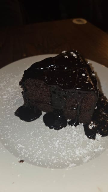 A short promotional video featuring a Matilda-inspired 'Bruce Bogtrotter' chocolate cake sharer at a Marston's pub. The video shows the cake being served, a fork digging into the rich chocolate sponge, and the creator taking a bite, followed by a shot of the menu description.