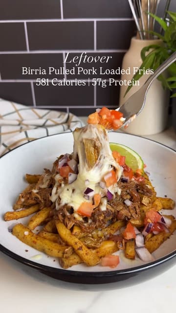 A recipe tutorial video demonstrating how to assemble birria pulled pork loaded fries, focusing on the high-protein aspect of the meal.