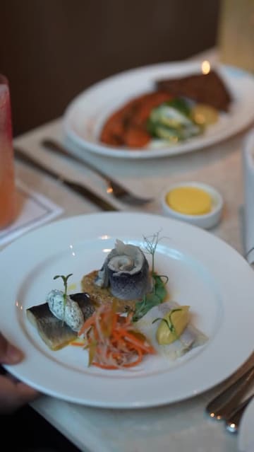 A high-quality promotional video for Brasserie Angelica and Gambit Bar at The Newman hotel, featuring a montage of the elegant interior, plated dishes like salmon and steak, craft cocktails, and the venue's atmosphere.