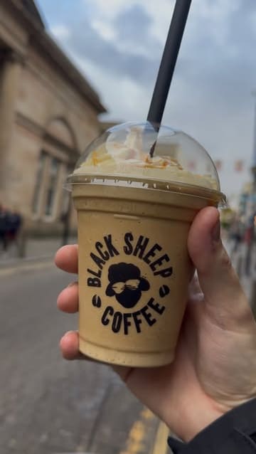 A creator visits the new Black Sheep Coffee location on Bold Street in Liverpool, showcasing the interior, the digital menu, and sampling a flat white, a cheese and ham toastie, and a billionaire shortbread.