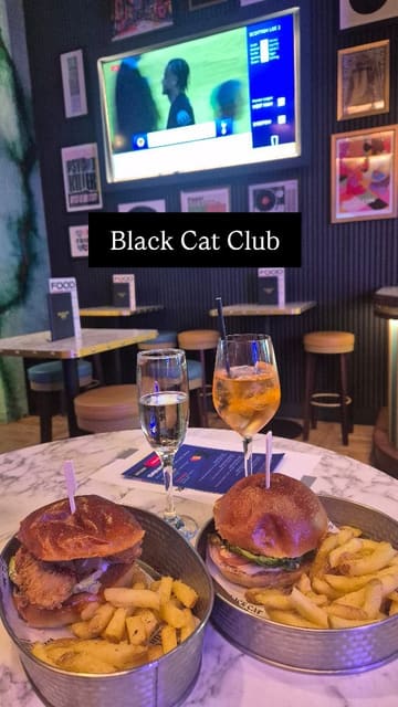 The video features a creator visiting the Black Cat Club for their Soccer Saturday bottomless brunch. It highlights the interactive bingo scorecard, the bottomless drinks, and the food (burger and fries) while explaining that the experience is enjoyable even for those not typically interested in football.