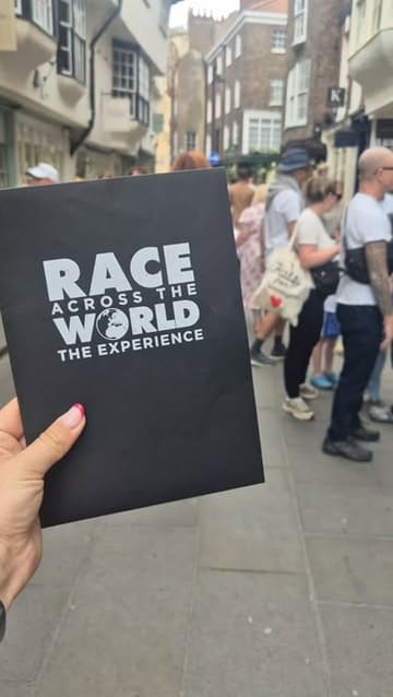 A group of friends participates in an interactive 'Race Across the World' scavenger hunt experience in York, solving puzzles and stopping for a Sunday roast at a local pub.