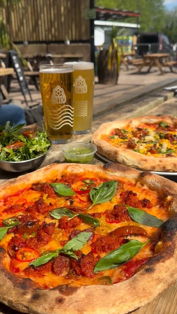 A short, punchy montage showcasing a visit to Deathrow Pizza, highlighting the build-your-own pizza ordering process, the food, and the casual outdoor seating environment.
