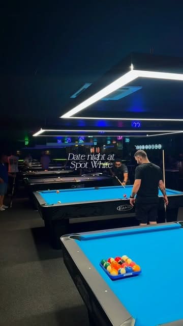 A fast-paced, energetic vlog-style video featuring a couple enjoying a date night at Spot White. The video highlights the venue's competitive socialising activities, including pool and darts, alongside a selection of casual pub-style food like burgers and nachos.