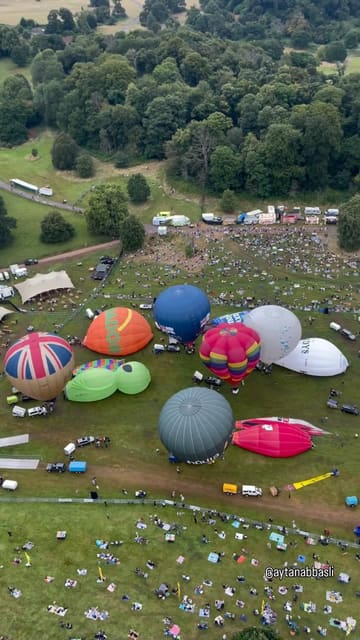 A montage video showcasing the Bristol Balloon Fiesta, featuring various shots of hot air balloons inflating, taking off, and flying over the landscape. The video highlights the scale and beauty of the event, using a mix of ground-level and aerial perspectives to create an immersive experience.