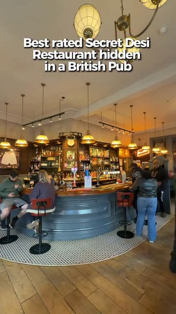 A video review of the Hen & Chickens pub in Birmingham, highlighting its status as a 'secret' Indian restaurant. The creator showcases the interior, the bar, and a variety of Indian dishes including a large grilled platter and curries, emphasizing the quality of the food over trendy aesthetics.