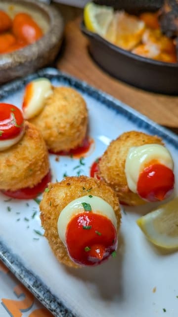 A promotional reel for El Gato Negro Tapas featuring a variety of dishes including gambas pil pil, patatas bravas, and croquetas, alongside shots of the restaurant interior and the creator enjoying the meal.