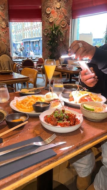 A promotional reel featuring a visit to Uba Shoreditch for a bottomless brunch, showcasing the venue's interior, various small plates, and cocktails.