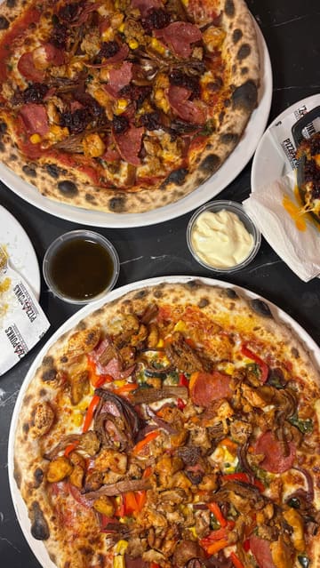 A promotional video for Pizza Punks featuring close-up shots of their new menu items, including pizzas, nduja mac and cheese, and loaded garlic bombs, set to upbeat music.