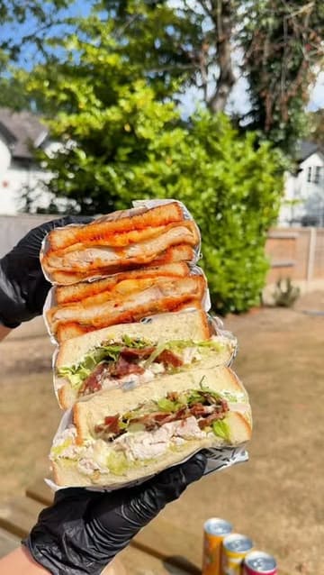 A fast-paced review of 'Between Bread' in Warrington, highlighting their loaded sandwiches made with Japanese milk bread, signature shoestring fries, and the shop's atmosphere.