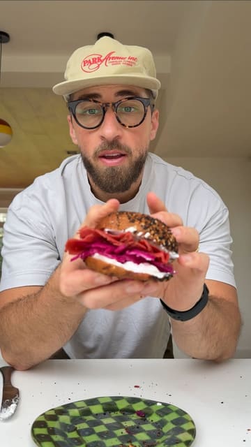 A polished, humorous recipe tutorial video demonstrating the process of making French onion bagels at home, presented by a creator in a 'trad dad' persona.