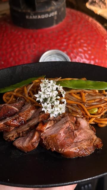 A first-person POV cooking video demonstrating how to marinate and sear duck breast on a Kamado Joe grill, served with a stir-fry.