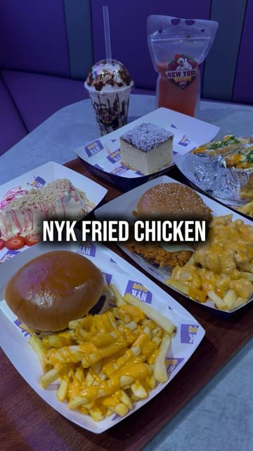 A promotional video for the new menu at NYK Fried Chicken in Bradford, featuring close-up shots of fried chicken burgers, loaded fries, cheesecake, and mocktails.