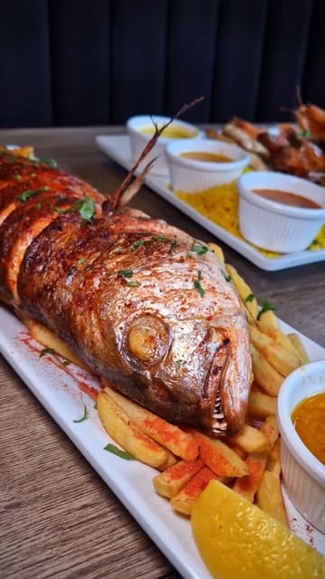 A promotional reel featuring a creator visiting Shrimp & Co to showcase their new menu items, including a large snapper, seafood platters, mocktails, and a chocolate lava cake.