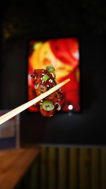A creator visits a new street food venue in Edinburgh, Chop & Wok Express, showcasing their menu items including loaded fries, noodles, and bao buns. The video features a mix of close-up food shots, interior glimpses, and the creator's reaction to the food.