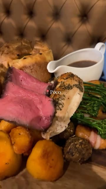 A short, handheld montage showcasing a Sunday roast dinner and drinks at a venue called Poco. The video features shots of the restaurant interior, a toast with wine, and close-ups of the roast dinner being served.