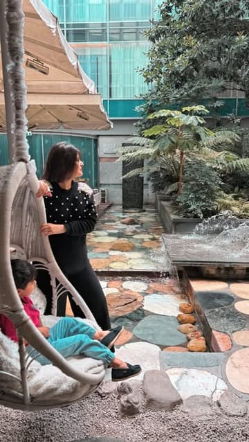A montage showcasing a family staycation at the Sanderson London, featuring shots of the hotel's quirky interiors, the courtyard, the room, and dining experiences.