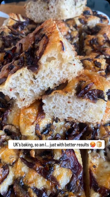 A short, handheld video showcasing a freshly baked mushroom and onion focaccia. The video focuses on the texture and appearance of the bread, with the creator holding a slice to demonstrate the crumb and toppings.