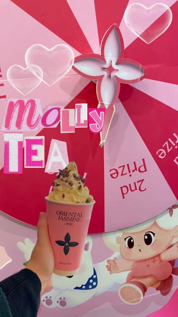 The video promotes a 'Back to School' event at Molly Tea, showcasing the menu, a lucky wheel prize game, and branded merchandise. It features close-ups of the drinks and the promotional signage, providing clear information about the offers available to students.
