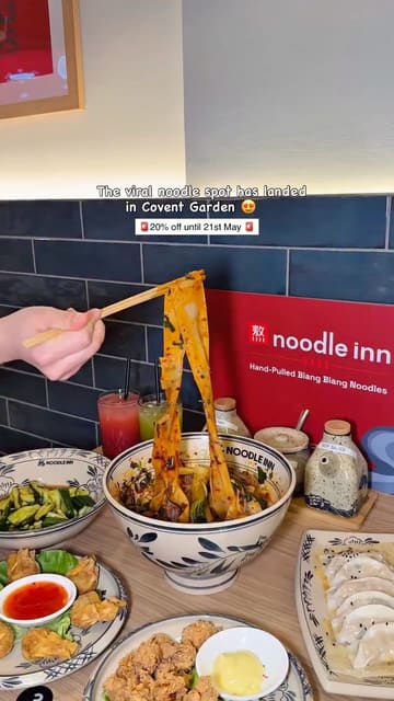 A vibrant food review of a new Noodle Inn location in Covent Garden. The video features the creator trying various dishes, including their signature biang biang noodles and a selection of sides, while providing a quick tour of the venue.