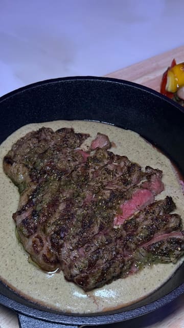 A montage of various dishes and drinks at Mynk Steakhouse, featuring close-up shots of lamb chops, prawns, steak, pasta, and dessert. The video focuses on the presentation and texture of the food, using smooth, controlled camera movements.