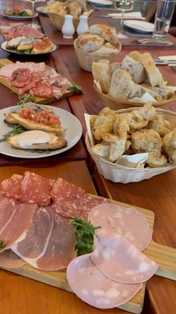 A promotional video for Luigi's Restaurant in Swansea, showcasing their group celebration set menu. The video features a montage of various Italian dishes, including antipasti, pasta, pizza, and desserts, alongside the menu details and wine.