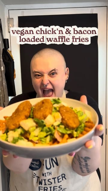 A home cooking tutorial demonstrating how to prepare a vegan loaded waffle fries dish using store-bought ingredients. The creator shows the process of air-frying the fries and vegan chicken, chopping salad ingredients, and assembling the final dish in a bowl.