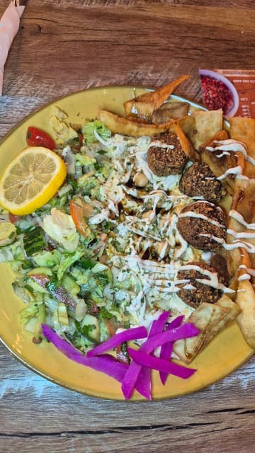 A montage showcasing the interior decor and various dishes from Giza, an Egyptian restaurant in Nottingham, including a falafel salad, kushari, and a loaded 'Munch Box'.