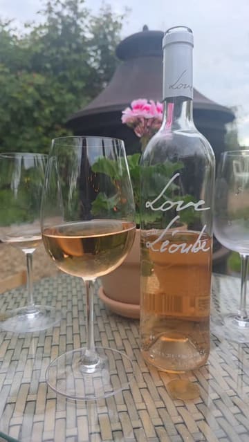 A montage showcasing a summer event at a riverside venue, featuring rosé wine, canapés, and a large grazing board in a beautifully decorated garden setting.