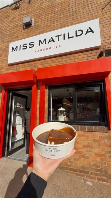 A short, fast-paced video showcasing various indulgent desserts from the newly opened Miss Matilda bakehouse, featuring close-up shots of cakes, cheesecakes, and puddings held in front of the shopfront.